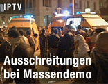 Zwei Rettungswagen umgeben von Demonstranten