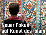 Eine Person fotografiert eine ausgestellte Fliesenwand