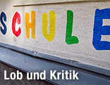 Das Wort Schule in bunten Buchstaben auf einer Gebäudewand