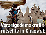 Eine Frau geht vor der roßer Moschee in Djenne
