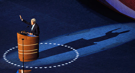 © Reuters/Steve Nesius US-Senator John Kerry steht auf einer Bühne im Rampenlicht und winkt