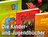 Aufgestellte Kinderbücher neben Weihnachtsdekoration