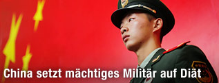 Chinesischer Soldat vor chinesischer Flagge