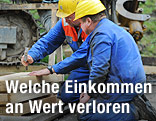Arbeiter mit Helm schlagen einen Nagel ein