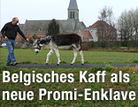 Ein Mann spaziert mit seinem Esel auf einem Feldweg nahe der Kirche in Nechin