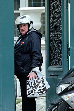 © Reuters/Benoit Tessier Der französische Schauspieler Gerard Depardieu steht mit Mopedhelm und Einkaufssackerln vor seinem Wohnsitz in Paris