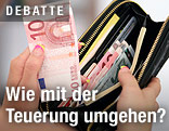 Eine Hand nimmt zehn Euro aus einer Geldb&ouml;rse