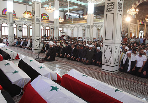 © APA/EPA/Youssef Badawi Menschen sitzen in Moschee, vorne stehen Särge