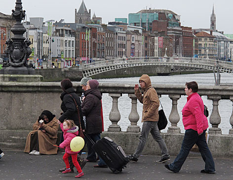 © AP/Shawn Pogatchnik Passanten überqueren eine Brücke in Dublin