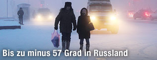 Menschen und Autos auf einer schneebedeckten Straße in Jakutsk, Russland