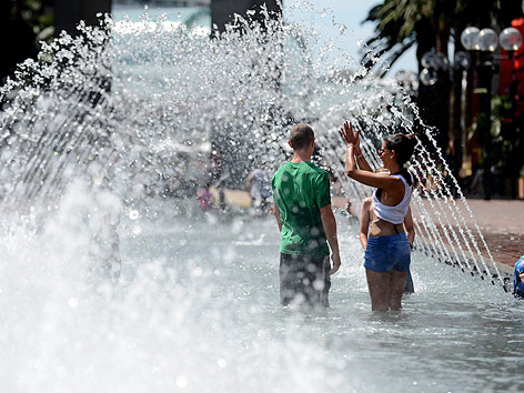© APA/EPA/Tracey Nearmy Menschen kühlen sich im Brunnen ab