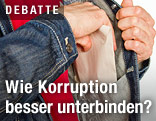 Mann holt Kuvert aus Jackentasche