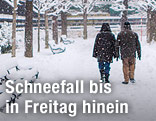 Menschen gehen im Schnee spazieren