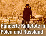 Eine Person mit warmer Mütze geht an frostbehangenen Bäumen vorbei