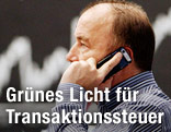 Telefonierender Börsenmakler mit Kurs im Hintergrund
