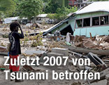 Ein Mann steht vor den Trümmern seines Hauses