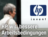 Frau geht an dem Firmenlogo von Hewlett Packard vorbei