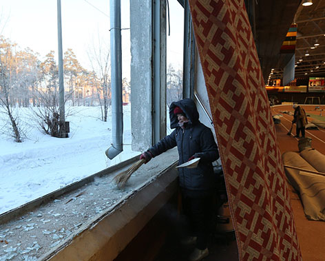 © APA/EPA/Sergei Ilnitsky Frau kehrt Glasscherben zusammen