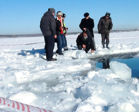 © APA/EPA/Russisches Innenministerium Menschen stehen bei Loch in Eisdecke von See