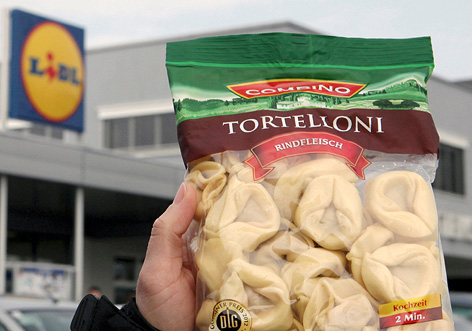 Hand mit einer Packung Tortelloni