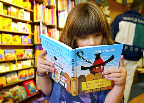 © APA/dpa/Della Valle Ein junges Mädchen liest im Kinderbuch "Räuber Hotzenplotz"