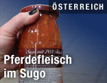 Hand mit einem Glas Sugo