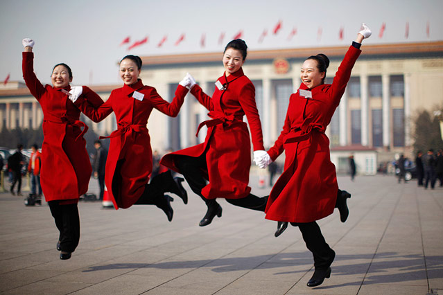 Junge Frauen springen für ein Foto am Tiananmen Platz