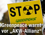 Hand hält ein Greenpeace-Schild