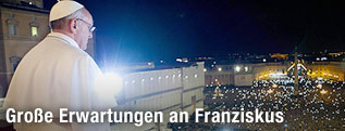 Papst Franziskus blickt von dem Balkon aus auf die Menschenmasse an Gläubigen auf dem Petersplatz