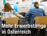 Menschen sitzen beim AMS vor Computer