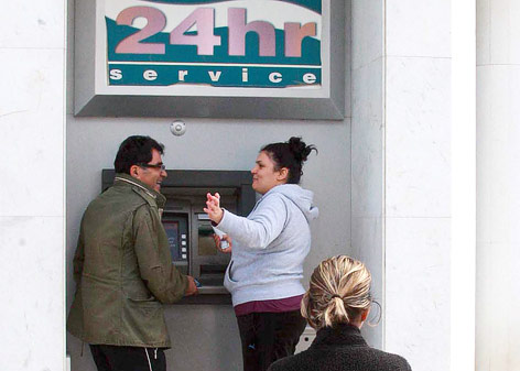 © APA/EPA/Christos Theodorides Personen stehen bei einem Bankomaten in Nikosia