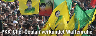 Kundgebungsteilnehmer mit Öcalans Kopf auf Fahnen