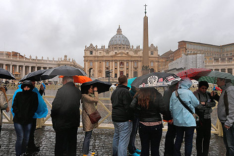 © APA/EPA/Valdrin Xhemaj Touristen mit Regenschirmen vor dem Petersdom