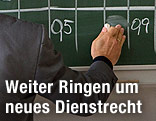Lehrer schreibt an eine Tafel