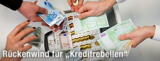 Mehrere Hände geben Geld in eine Kasse
