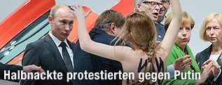 Eine halbnackte Femen-Demonstrantin läuft auf den russischen Präsidenten Wladimir Putin zu