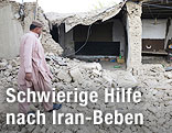 Mann vor einem, durch ein Erdbeben zerstörtem, Haus