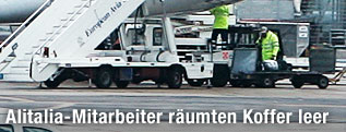 Männer räumen Koffer in Flugzeug