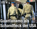 Häftling wird in Guantanamo von zwei Wärtern begleitet