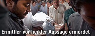 Der Leichnam des ermordeten Chaudhry Zulfikar wird in ein Ambulanzauto gehoben