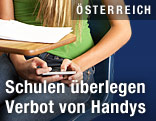 Schülerin arbeitet mit Handy unter der Schulbank
