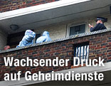 Polizisten untersuchen die Wohnung eines Verd&auml;chtigen