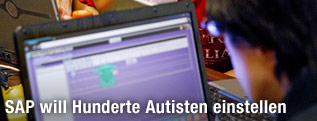 Menschen arbeiten an Laptops