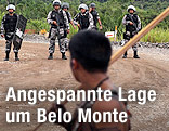 Indigener mit Holzstange vor brasilianischen Polizisten