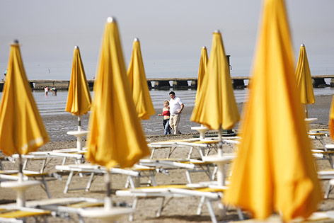 © Corbis/Michal Fludra Ein Paar wandert auf einem leeren Strand in Grado