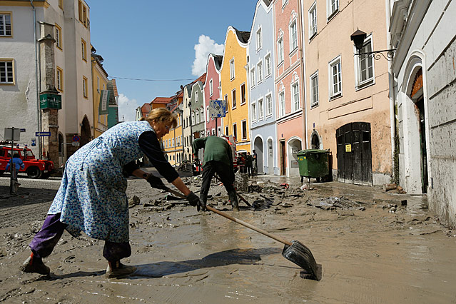 © Reuters/Wolfgang Rattay Frau kehrt Schlamm auf der Straße