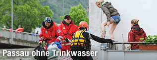 Eine junge Frau wird von Rettungskräften in einem Boot in Sicherheitgebracht