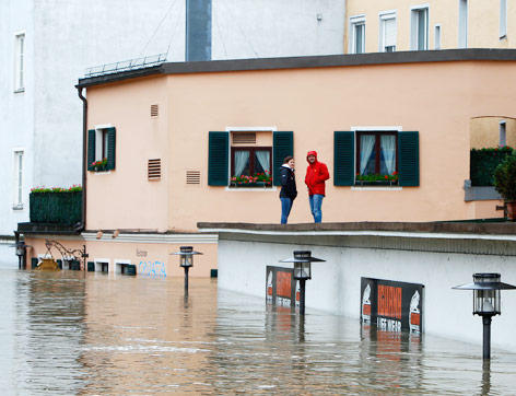 Zwei Personen stehen auf dem Dach eines Hauses