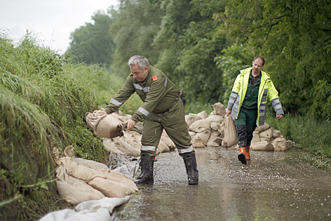 © APA/Georg Hochmuth Feuerwehrmänner bringen Sandsäcke aus