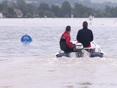 © APA/Rubra Motorboot und überflutete Verkehrszeichen